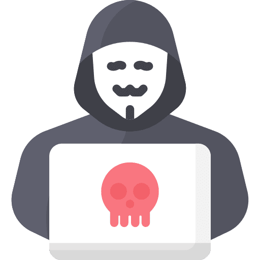 A man at home, wearing a hoodie while holding a laptop with a skull on it.